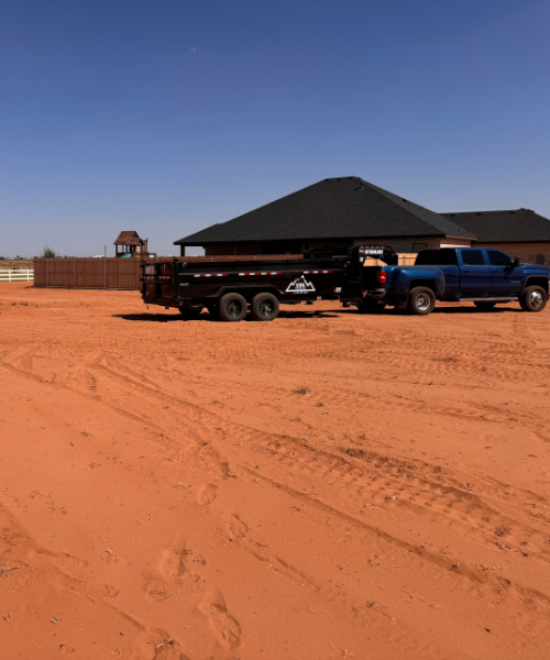 A truck is parked in the middle of a dirt road