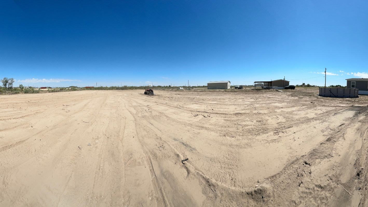 A truck driving down a dirt road next to a building