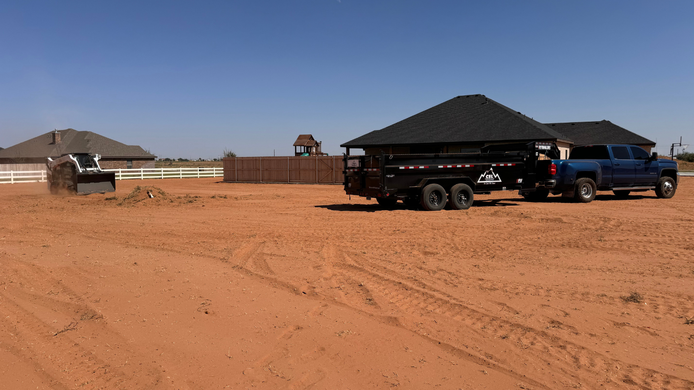 A dump truck is parked in a dirt lot