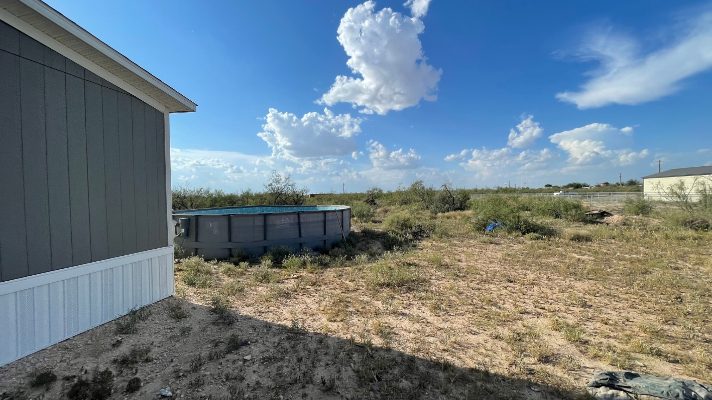 A house with a pool in the middle of a field